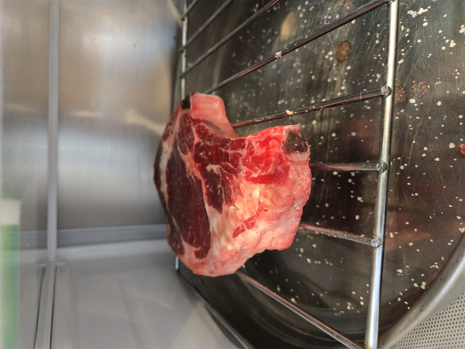 Bone-in ribeye dry-brining on a rack before cooking